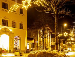 une rue la nuit avec des lumières de Noël sur un arbre dans l'établissement GORI Boutique Apartments – Tirol, à Reutte