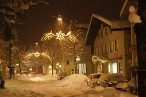 una calle de la ciudad cubierta de nieve por la noche en GORI Boutique Apartments – Tirol, en Reutte