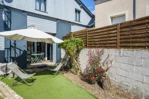 Un patio con sombrilla y sillas y una mesa. en Atelier loft proche Halles Tours, en Tours
