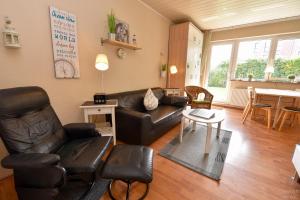 ein Wohnzimmer mit einem Ledersofa und einem Tisch in der Unterkunft Haus Kehrwieder Appartement KEHR8 in Cuxhaven