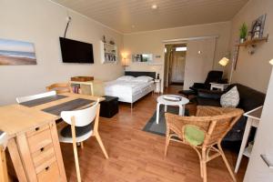 ein Wohnzimmer mit einem Bett, einem Tisch und Stühlen in der Unterkunft Haus Kehrwieder Appartement KEHR8 in Cuxhaven