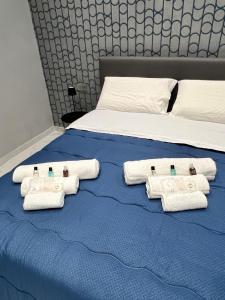 Una cama con toallas y botellas de agua. en Fly Home, en Nápoles