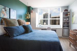 Un dormitorio con una cama azul y una ventana en Adorable 12th Floor Standard Unit Parking Included, en Miami