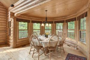 ein Esszimmer in einer Blockhütte mit Tisch und Stühlen in der Unterkunft Le Cerf #40 in Mille-Isles