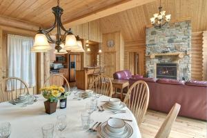 a dining room with a table and a fireplace at Le Cerf #40 in Mille-Isles +37 photos