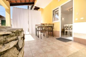 a dining room with a table and chairs and a stone wall at House Violica in Vodice