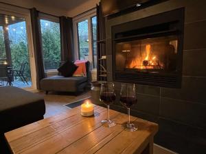 dos copas de vino en una mesa frente a una chimenea en Beautiful Condo 3-Eleven at Tremblant, en Mont-Tremblant
