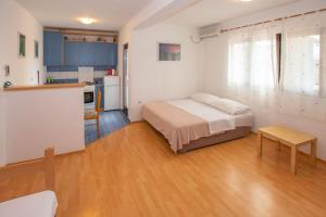 a small bedroom with a bed and a kitchen at Apartments Barbara in Pakoštane