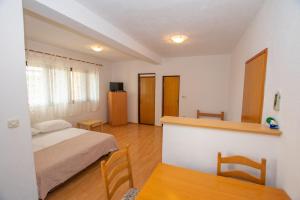 a bedroom with a bed and a table and chairs at Apartments Barbara in Pakoštane