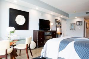 ein Schlafzimmer mit einem Bett, einem Tisch und einem Fernseher in der Unterkunft Deluxe Studio in Coconut Grove City and Bay views Includes Parking in Miami