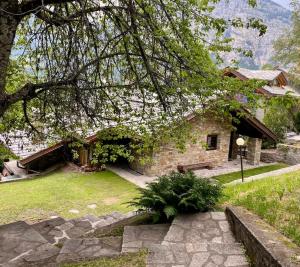 Relais Courmayeur - Fiore di bosco - Mont Blanc - Italia في كورمايور: بيت حجري امامه محطه