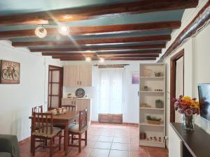 a kitchen and dining room with a table and chairs at Ca l'Èndula II in Lucena del Cid