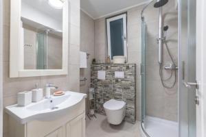 uma casa de banho com um WC, um lavatório e um chuveiro em Apartments and Room Poesia em Split