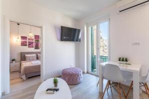 uma sala de estar branca com uma cama e uma mesa em Apartments and Room Poesia em Split