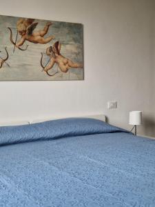 a bedroom with a bed with a painting on the wall at HomeLame 57 in Bologna