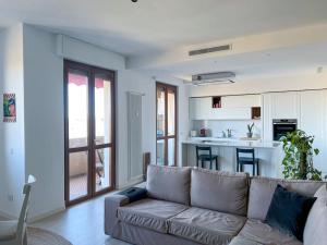 een woonkamer met een bank en een keuken bij Urban Penthouse - Milan & Rho Fiera in Bresso