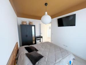 een slaapkamer met een bed en een televisie in een kamer bij Urban Penthouse - Milan & Rho Fiera in Bresso