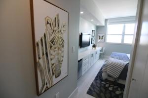 a bedroom with a tv and a painting on the wall at Renovated 21st Floor Private Unit located in Coconut Grove Hotel in Miami