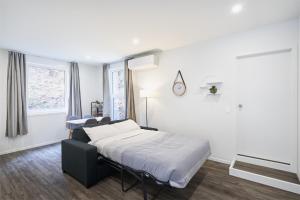 um quarto branco com uma cama e uma janela em Modern Home Near Town em Dunedin