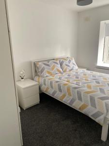 a bedroom with a bed and a night stand at Modern comfortable four bedroom house in great location in Dublin