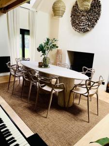 a dining room with a table and chairs and a piano at Maison UMI 
