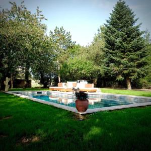 una piscina en un patio con césped verde en Maison UMI 