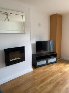 uma sala de estar com televisão e lareira em Modern comfortable four bedroom house in great location em Dublin