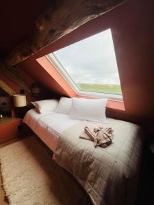Bett in einem Zimmer mit einem großen Fenster in der Unterkunft Maison UMI 