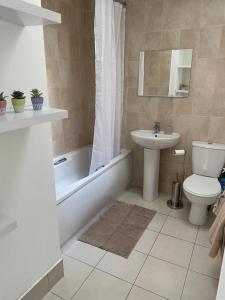 een badkamer met een toilet, een wastafel en een bad bij Modern comfortable four bedroom house in great location in Dublin