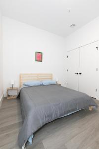a bedroom with a large bed and a white wall at Modern Contemporary 2-Bed Apt Close to NYC in Bayonne