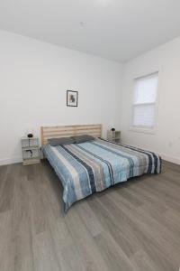 a bedroom with a bed and a wooden floor at Modern Contemporary 2-Bed Apt Close to NYC in Bayonne