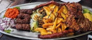 Endo Mando في Shellal: طبق من الطعام مع النقانق والبطاطا المقلية