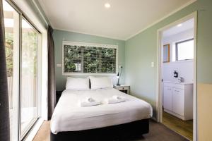 Tasman Holiday Parks - Beachaven في شاطئ وايهي: غرفة نوم عليها سرير وفوط
