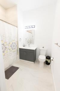 a white bathroom with a sink and a toilet at Modern Contemporary 2-Bed Apt Close to NYC in Bayonne
