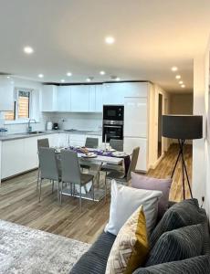 een woonkamer en een keuken met een tafel en stoelen bij Comfort and Style ! in Addington