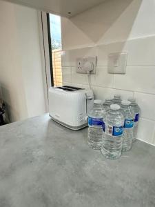 a group of bottles of water next to a toaster at Comfort and Style ! in Addington