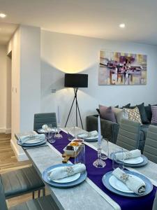mesa de comedor con platos y vasos y sofá en Comfort and Style ! en Addington