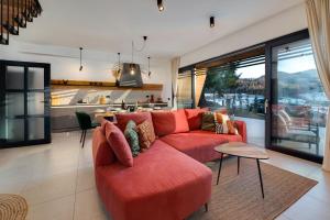a living room with a red couch and a kitchen at Villa Bellis in Mrkopalj