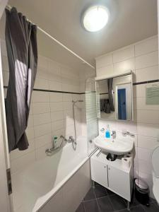 La salle de bains est pourvue d'un lavabo, d'une baignoire et de toilettes. dans l'établissement Residence Geneva Quartier de Plainpalais, à Genève