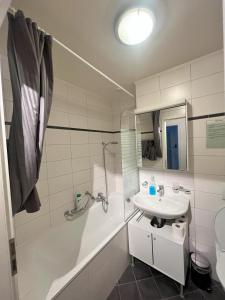 a bathroom with a sink and a tub and a toilet at Residence Geneva Quartier de Plainpalais in Geneva