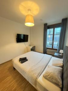 sypialnia z dużym łóżkiem i dużym oknem w obiekcie Residence Geneva Quartier de Plainpalais w Genewie