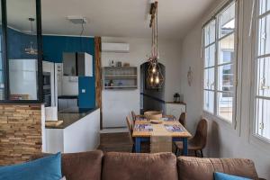 een woonkamer met een tafel en een keuken bij Family cocoon by the sea in La Tranche-sur-Mer