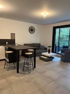 Appartement proche de Genève 2 في Collonges-sous-Salève: غرفة معيشة مع طاولة سوداء وكراسي