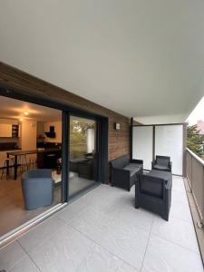 een patio met stoelen en een woonkamer bij Appartement proche de Genève 2 in Collonges-sous-Salève