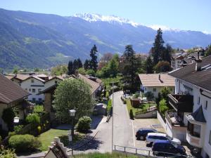 a town with cars parked on a street with a mountain at Residence Sonnenburger in Parcines