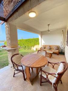Una mesa y sillas de madera en un patio. en فيلا أول صف على البحيرة مارينا 5ج2, en El Alamein