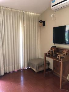 sala de estar con TV de pantalla plana junto a una ventana en La Pedra Hotel Boutique, Raco in 