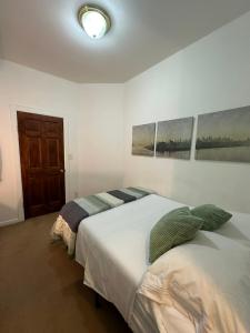 sypialnia z dwoma łóżkami i dwoma obrazami na ścianie w obiekcie Comfy Guest House by Columbus Circle w Nowym Jorku