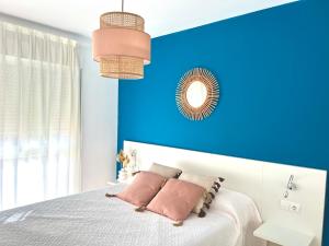 a bedroom with blue walls and a bed with pillows at BORA BORA Ático con piscina privada en Vera Paraíso in Vera +21 photos