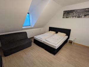 een kleine slaapkamer met een bed en een stoel bij Cityhouse - Wiesen in Wuppertal
